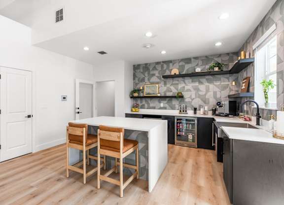 A kitchen with a table and chairs in the middle of the room.