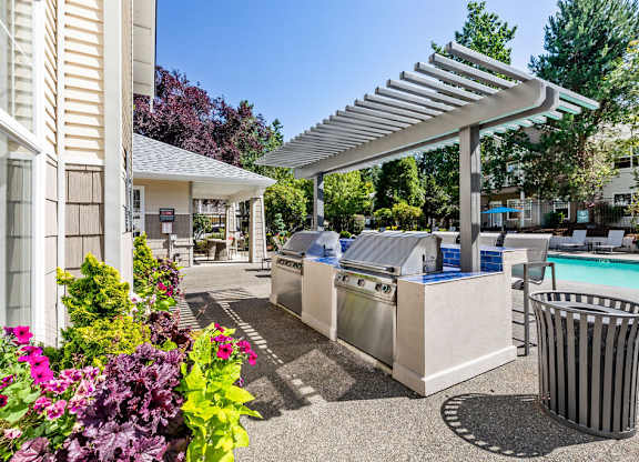 A poolside area with a trash can and a trash can cover.