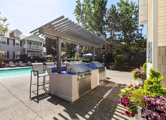 A poolside area with a hot tub and a barbecue grill.