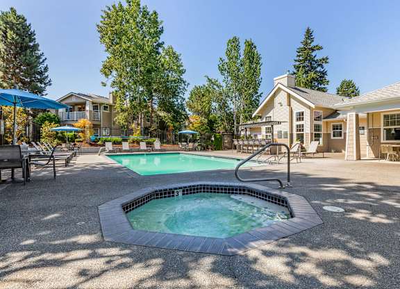 A small pool with a hot tub in the middle of a patio.