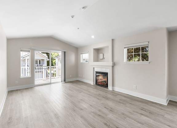 A spacious living room with a fireplace and sliding glass doors.
