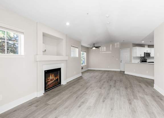 A spacious living room with a fireplace and hardwood floors.