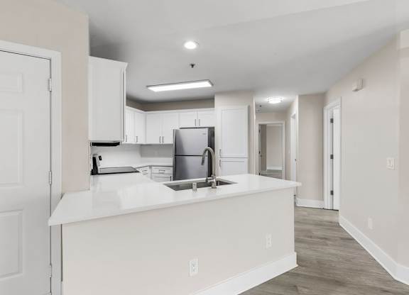 A kitchen with white cabinets and a white countertop.