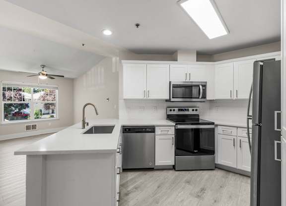 A modern kitchen with stainless steel appliances and white cabinets.