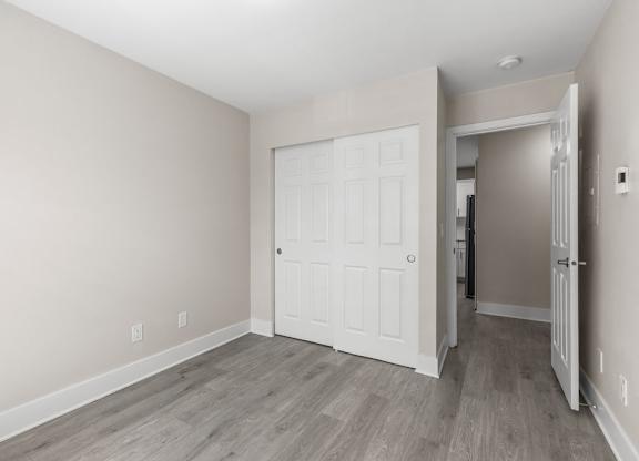 A room with a white door and a grey floor.