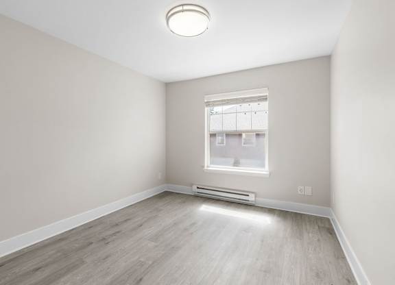 A room with a window and a radiator on the wall.