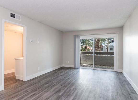 A room with a sliding glass door leading to a balcony.