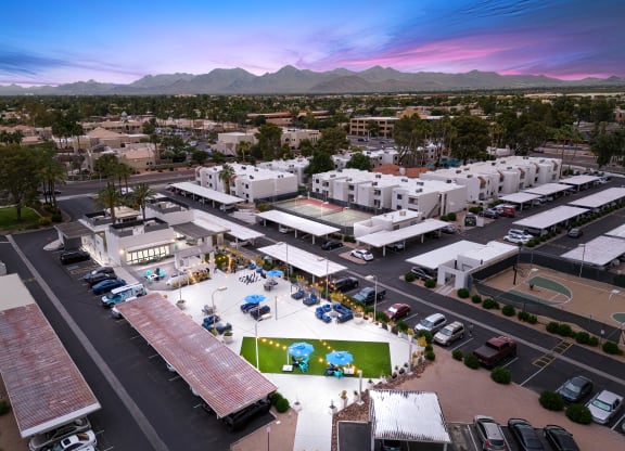 an aerial view of the community at sunset with mountains in the background