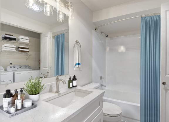 a bathroom with white walls and a blue shower curtain