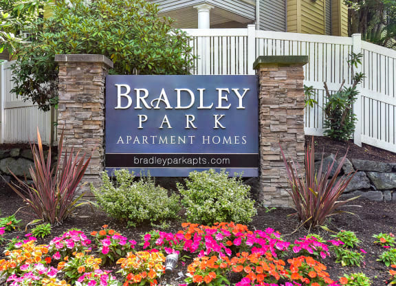 a sign apartment homes in front of flowers