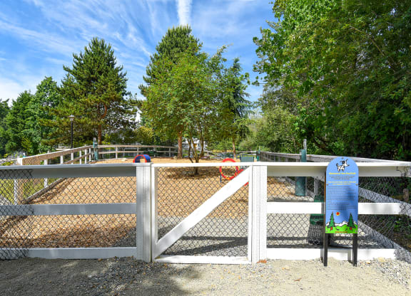 a white fence with a white gate and a blue sign on the side of the fence
