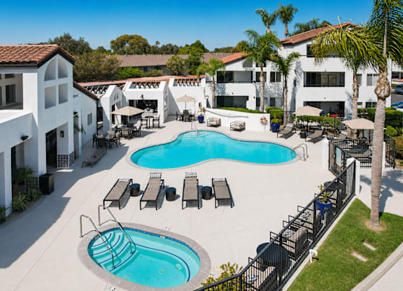 A large swimming pool surrounded by lounge chairs and umbrellas.