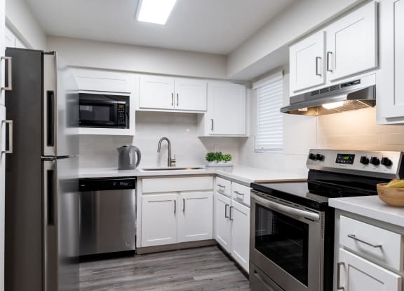 a kitchen with white cabinets and stainless steel appliances