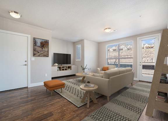 A living room with a couch, a chair, a coffee table, and a television.