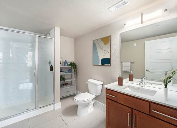 A bathroom with a toilet, sink, and shower.