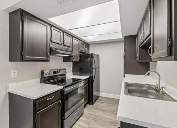 A kitchen with dark brown cabinets and stainless steel appliances.