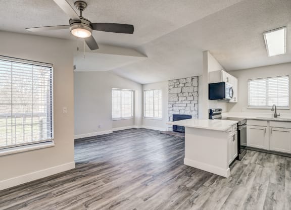 a kitchen and living room with a ceiling fan