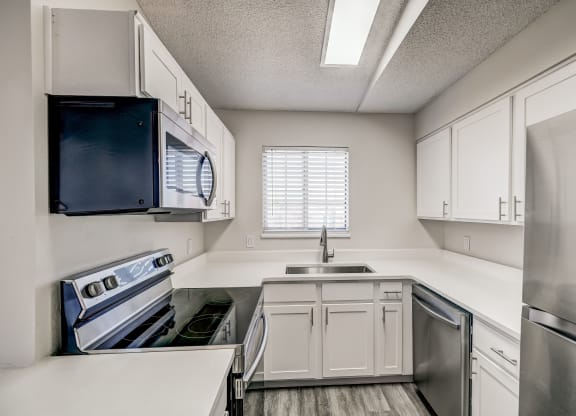 a kitchen with white cabinets and stainless steel appliances