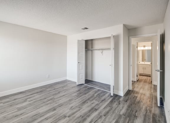 a bedroom with hardwood flooring and white walls