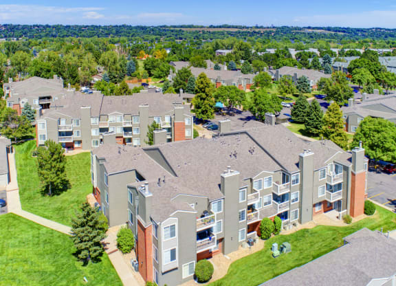 an aerial view of an apartment complex with green grass and trees