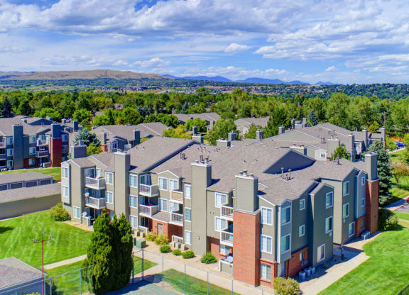 an aerial view of an apartment complex with green grass and trees