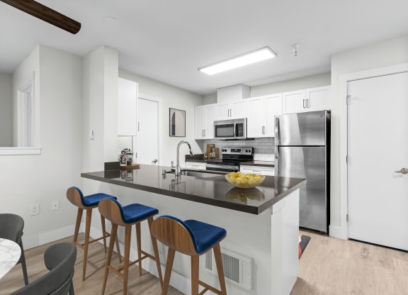 a kitchen with a large center island with a breakfast bar and three stools