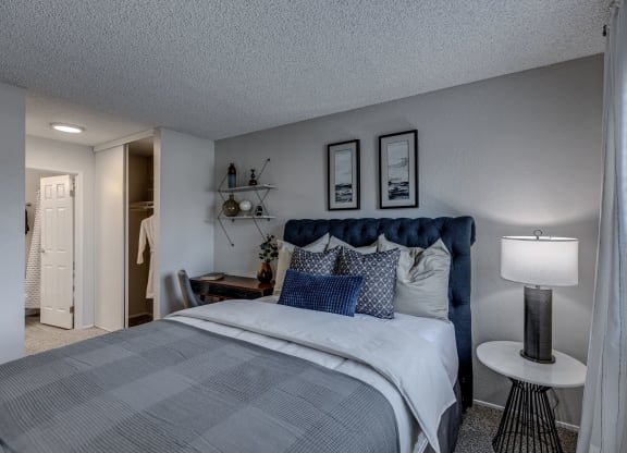 a bedroom with a bed and a nightstand with a lamp