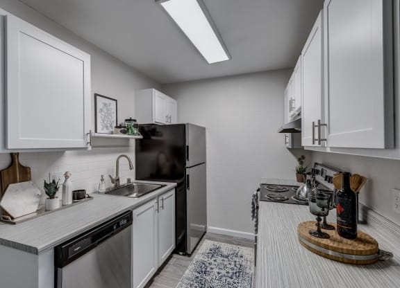 a kitchen with white cabinets and stainless steel appliances