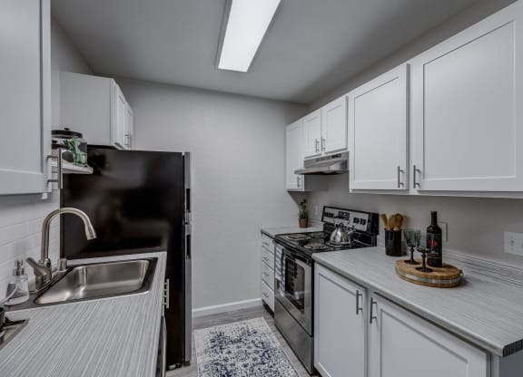 a kitchen with white cabinets and stainless steel appliances