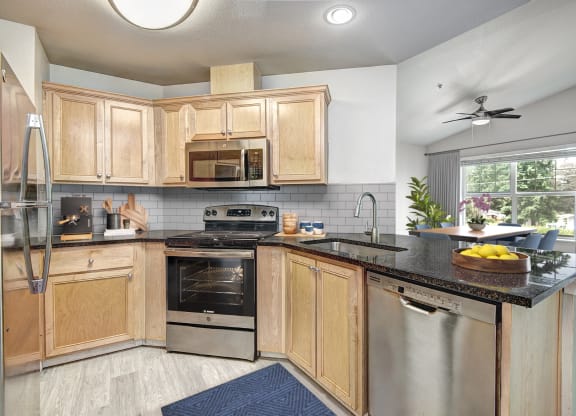 a kitchen with wooden cabinets and a black counter top