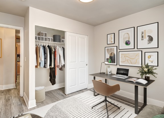 a closet in a bedroom with a desk and chair