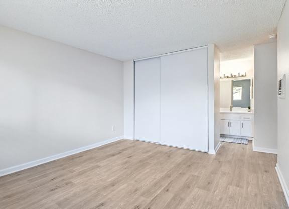 A room with a white wall and a white closet door.