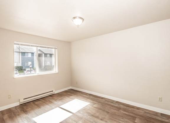 A room with a window and a radiator on the floor.