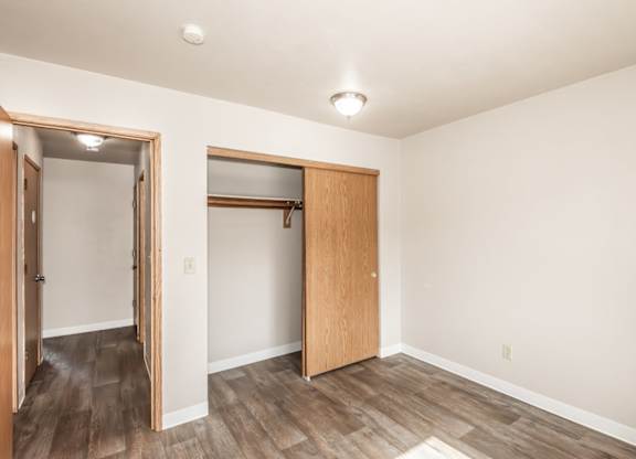 A room with a wooden floor and a white ceiling with a light fixture.