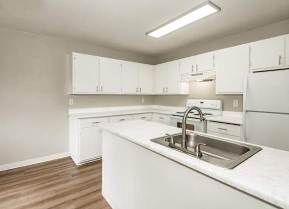 A kitchen with white cabinets and a sink.