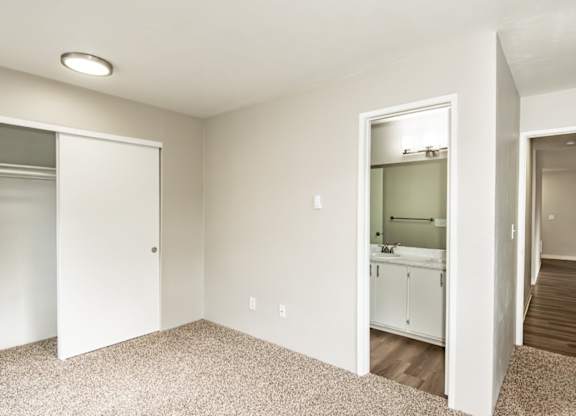 A white bathroom with a white door and a white cabinet.