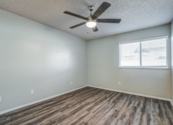 an empty living room with a ceiling fan and a windowat Aspire Seneca, Victorville, CA