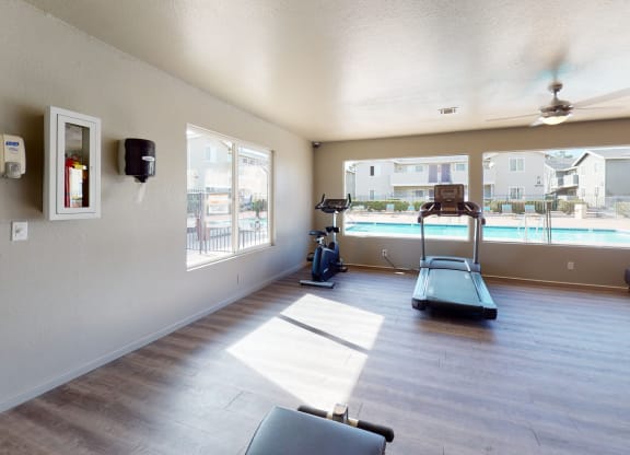 Fitness Center with an Exercise Bike, Treadmills, and View of the Pool at Aspire High Desert Apartments, Victorville, CA, 92392