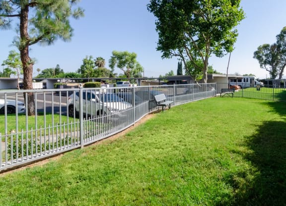 a yard with a fence and benches in a park at Aspire Corona, California, 92882