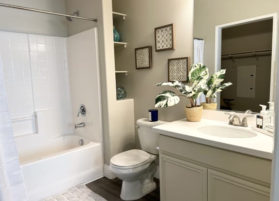 a bathroom with a white toilet next to a white bathtub at Riverton of the High Desert Apartments, Victorville