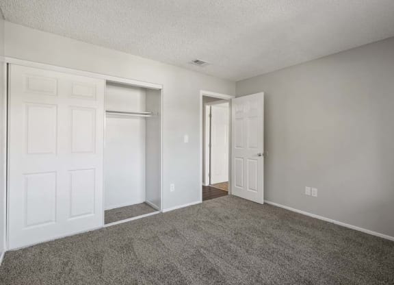 a bedroom with two doors and a carpeted floor at Aspire Redlands, Redlands, 92374