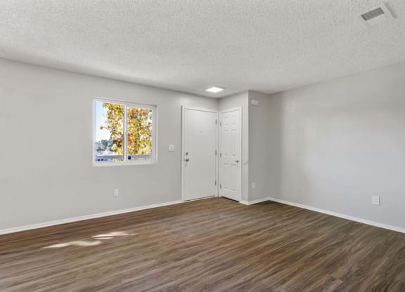 an empty bedroom with hardwood floors and a door to the bathroom at Aspire Redlands, Redlands, 92374