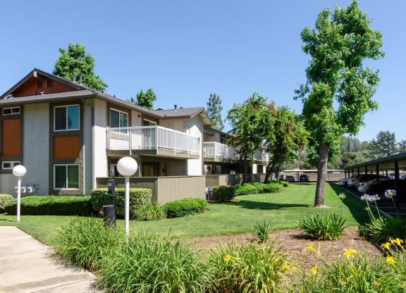 an apartment building with a lawn and trees in front of it at Aspire Redlands, California