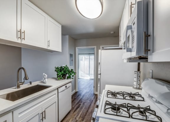 a kitchen with white cabinets and a sink and a stove at Aspire Seneca, Victorville