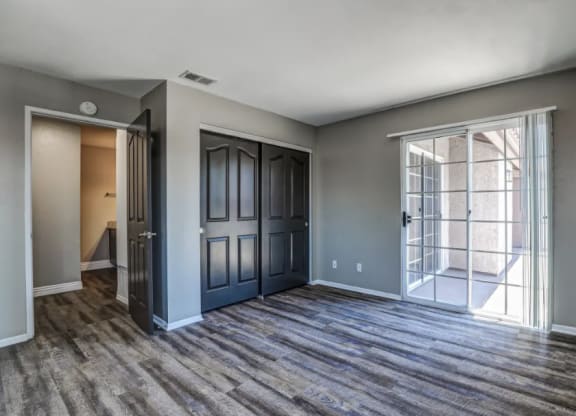 the living room of a new home with doors and a window at Vista Promenade Apartments, Temecula