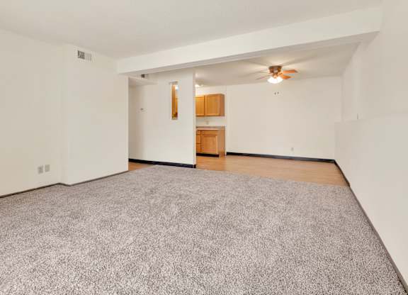 A room with a grey carpet and a ceiling fan. at Winding Hills Apartments, Davenport , IA, 52807