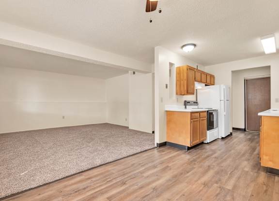 A spacious living room with a kitchenette and hardwood floors. at Winding Hills Apartments, Davenport