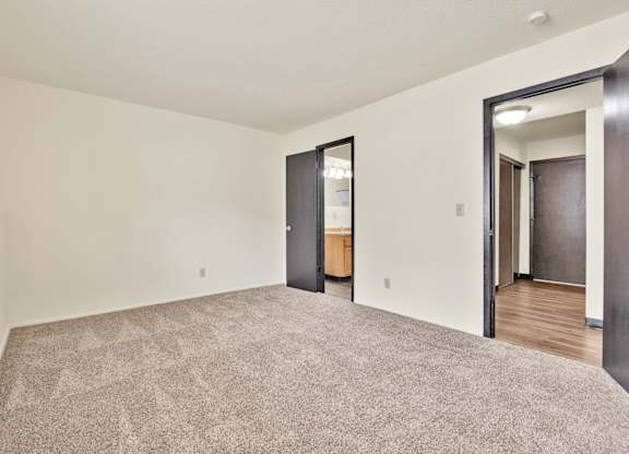A room with a carpeted floor and two doors. at Winding Hills Apartments, Davenport , IA