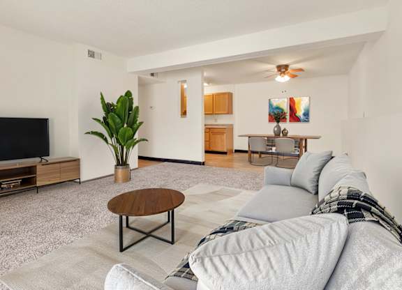 A living room with a grey couch and a wooden coffee table at Winding Hills Apartments, Davenport , IA, 52807