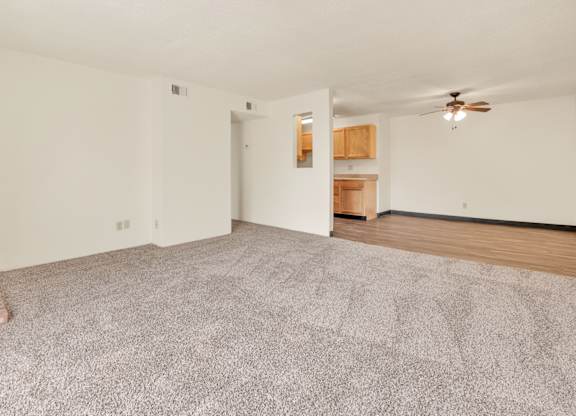 A room with a carpeted floor and a ceiling fan. at Winding Hills Apartments, Davenport  52807
